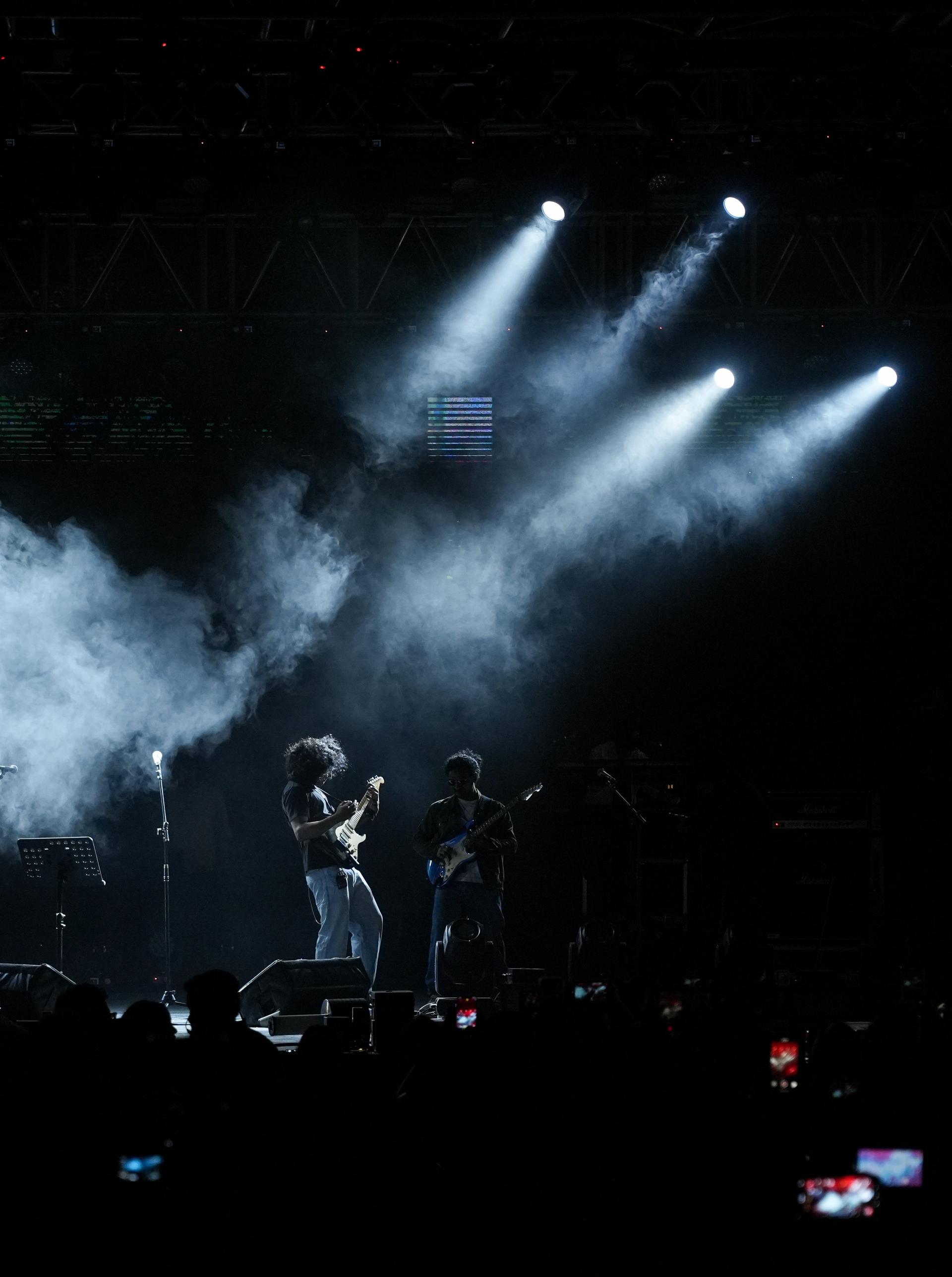 Live band performing on stage with dramatic lighting