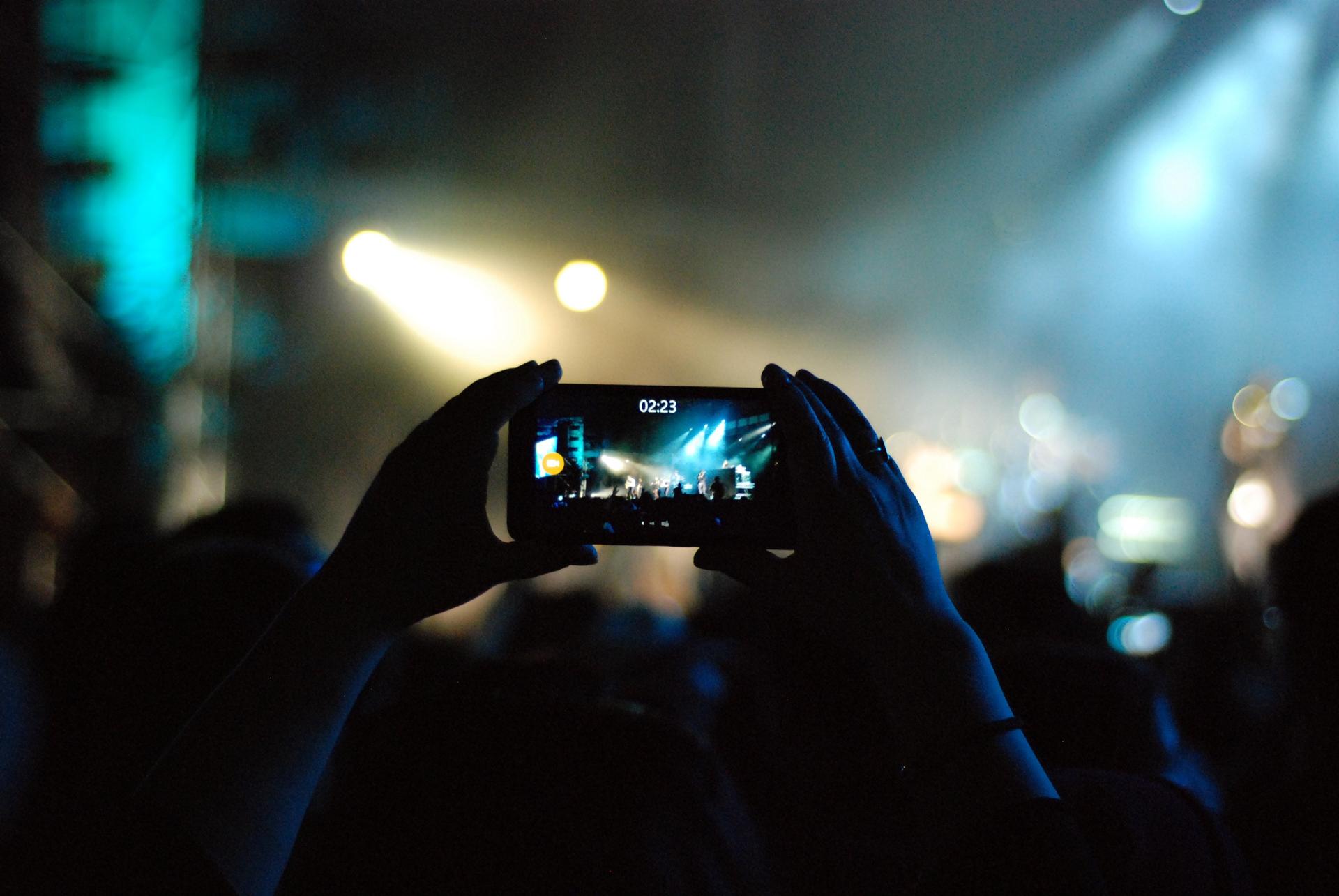 Person capturing a live performance on their phone